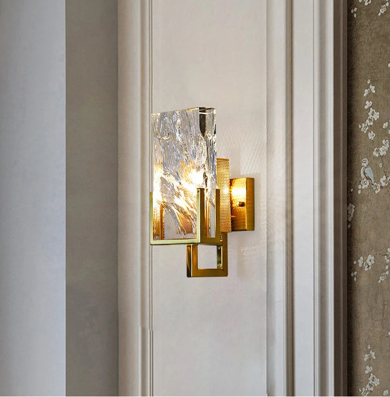 Decorative wall sconce with glass shade on a neutral wall.