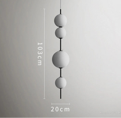 Modern pendant light with three spherical shades on a gray background