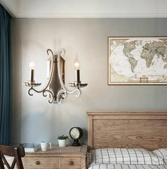Bedroom interior with wooden headboard, nightstand, and wall sconces.