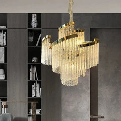 Luxury chandelier hanging in a modern interior setting with a bookshelf in the background.