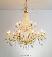 Gold chandelier with crystal accents on a plain background