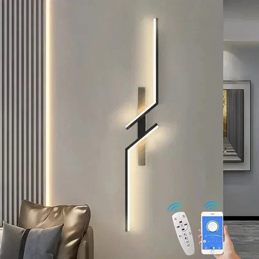 Modern geometric wall sconce with a gold finish and sharp angles, emitting a warm light, shown on a neutral wall.