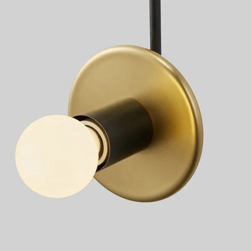 Gold and black light fixture on a gray background