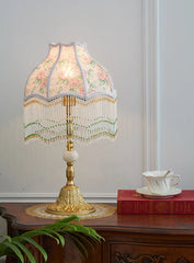 Decorative lamp with floral lampshade on a wooden table.