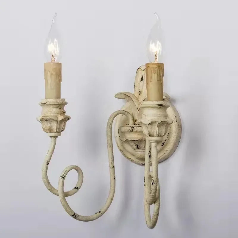 Vintage-style wall sconce with two candles on a plain background