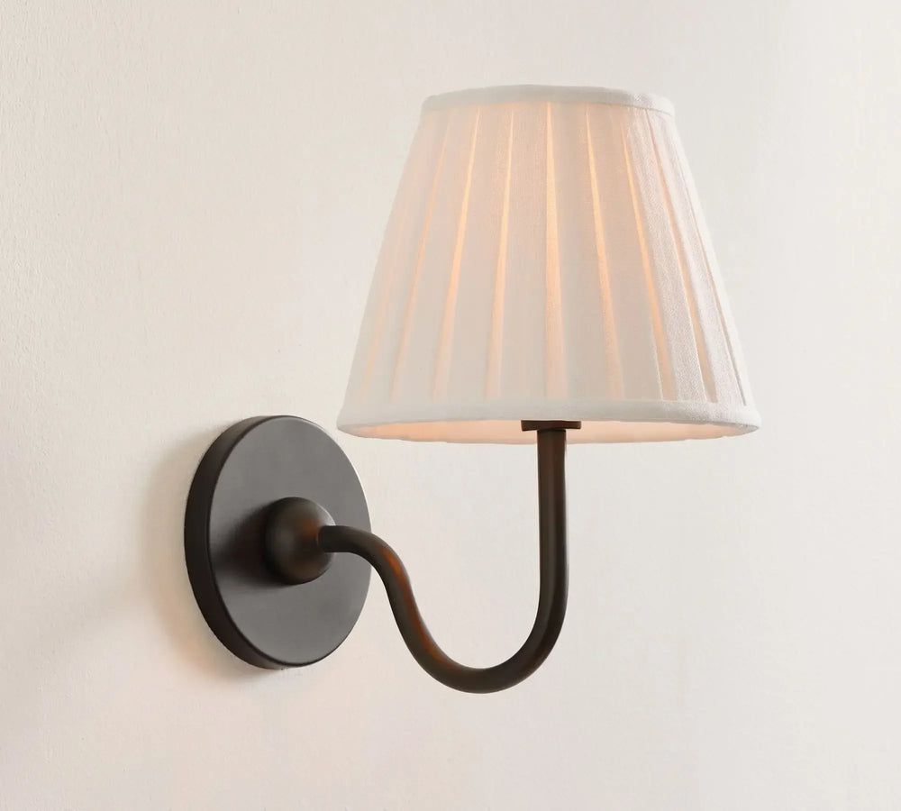 Wall-mounted lamp with a white shade on a light gray background