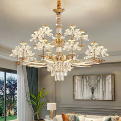 A close-up of a gold chandelier with crystal flower accents and cascading teardrop crystals hanging from a ceiling.
