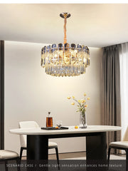 The gold crystal chandelier, viewed from a slightly different angle, highlighting its circular shape and shimmering crystals.