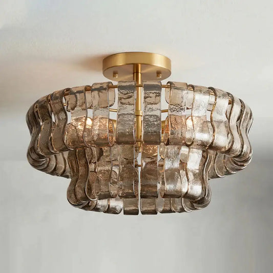 Gold wavy glass semi-flush mount chandelier with a brass-finished ceiling canopy against a white ceiling