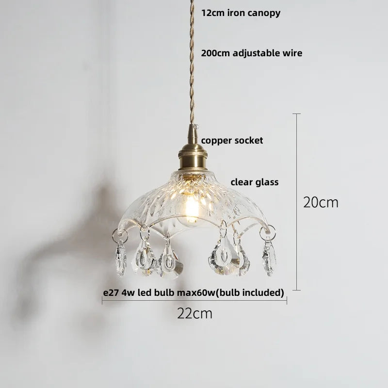Pendant light with clear glass shade and decorative elements on a white background
