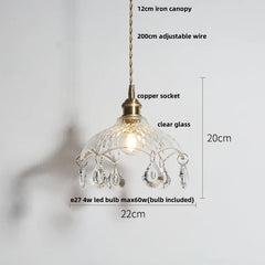 Pendant light with clear glass shade and decorative elements on a white background