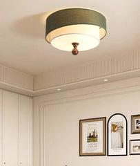 Ceiling light fixture in a room with framed pictures on the wall.