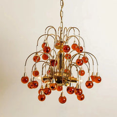A similar chandelier design in a red/amber hue with gold metal accents.