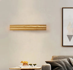 Modern wall lamp on a neutral wall with a sofa and side table in the foreground.