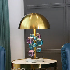 Close-up of the colorful crystal globes and gold stem of the table lamp.