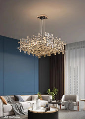 Modern chandelier hanging in a stylish living room with blue walls and gray furniture.