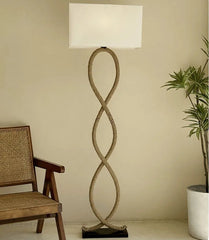 Floor lamp with twisted design next to a wooden chair and plant on a beige background