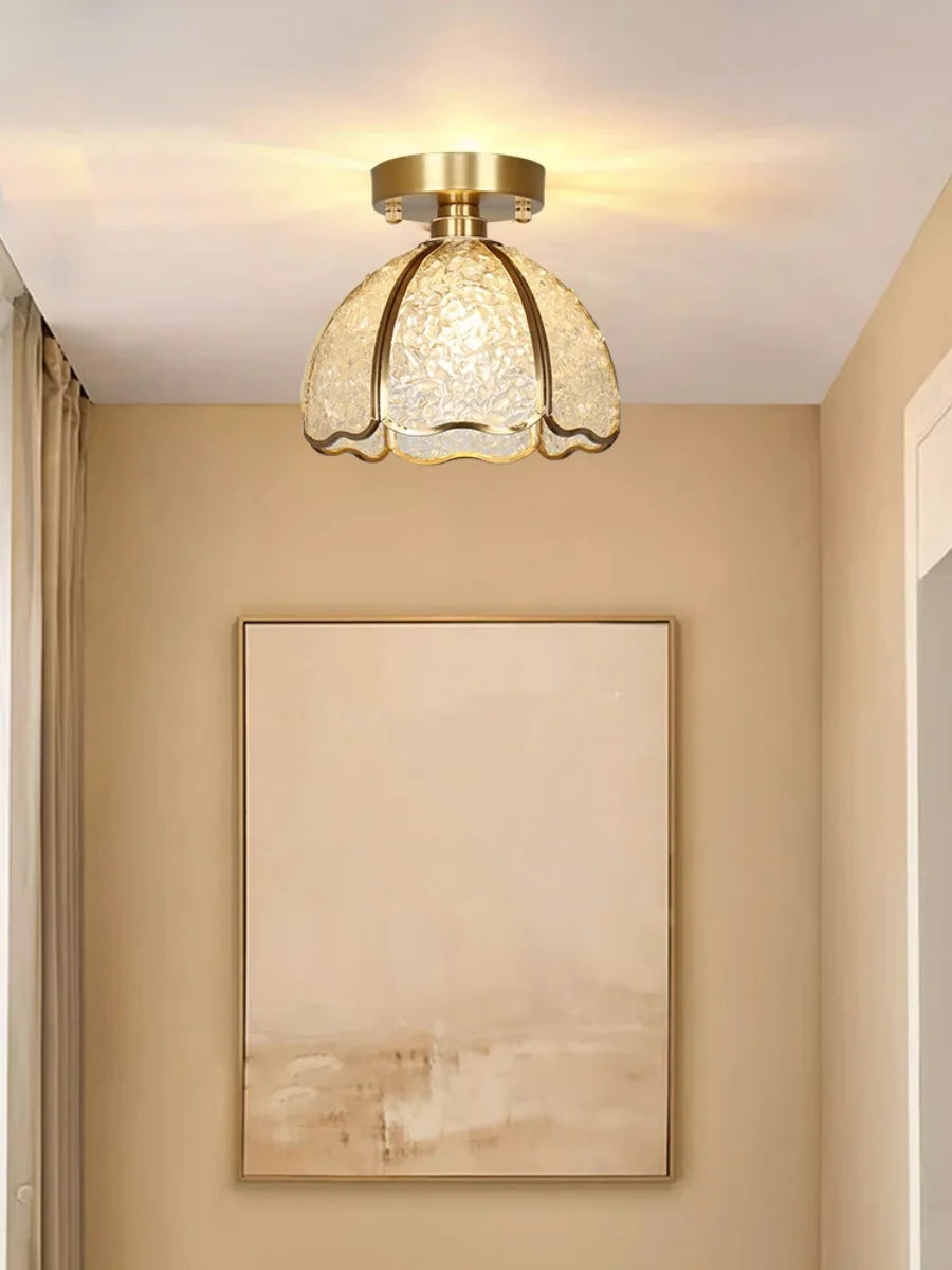Ceiling light fixture in a room with beige walls and a painting.