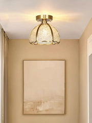 Ceiling light fixture in a room with beige walls and a painting.