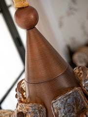 Close-up of a decorative wooden object with intricate carvings and a textured surface.
