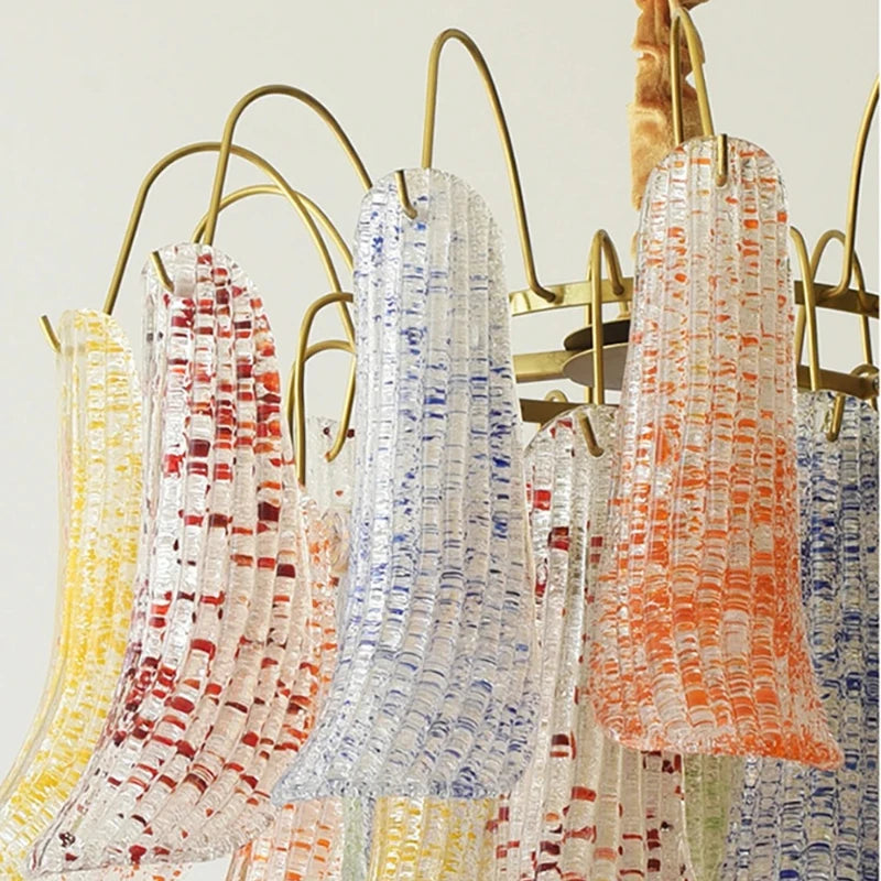 Detail shot of multi-colored glass elements (yellow, red, blue, orange) on a gold chandelier frame.
