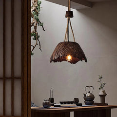 Wooden pendant light hanging in a room with a table and decorative items.