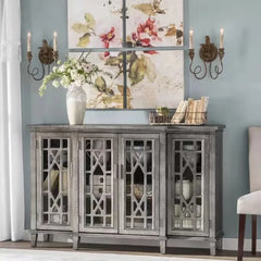 Decorative sideboard with floral painting, candles, and books against a light blue wall.