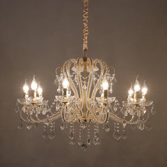 Gold crystal candelabra chandelier against a dark background, with bright light.
