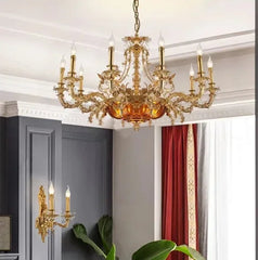 Gold chandelier hanging in a room with gray walls and red curtains.