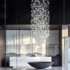 Modern interior with a large crystal chandelier, reflective surfaces, and a mountain-themed wall.