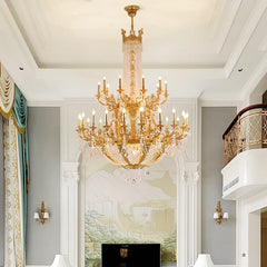 A wide shot of a gold tiered crystal candelabra chandelier in a living area with a large mural and decorative curtains.