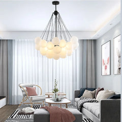 Modern living room with a chandelier, sofa, and armchair.