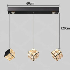 Modern pendant light fixture with crystal shades and dimensions indicated on a gray background