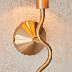 Gold wall sconce on a textured wall