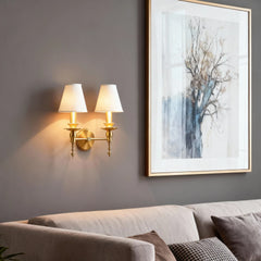 Living room with a sofa, wall sconces, and framed artwork on a gray wall.