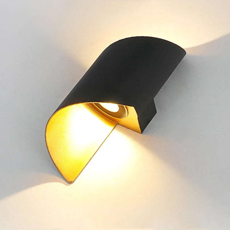 “Curved black and gold LED wall lamp casting warm up-and-down lighting.”