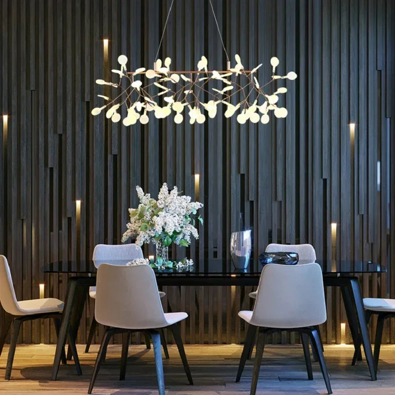 Modern dining room with a chandelier, table, and chairs against a dark paneled wall.