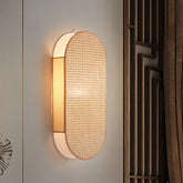 Wall-mounted light fixture with woven design on a neutral wall.