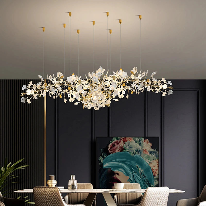Modern chandelier hanging above a dining table with a dark wall and artwork in the background.