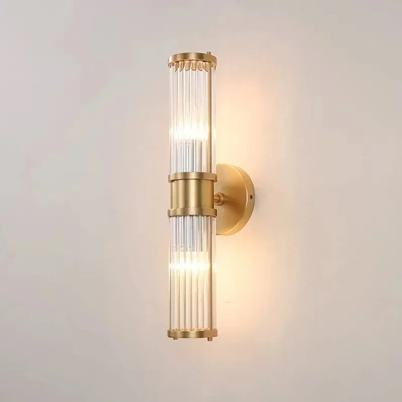 Gold wall sconce with glass shade on a light gray background
