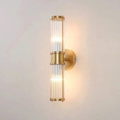 Gold wall sconce with glass shade on a light gray background