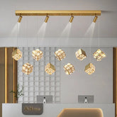 Modern ceiling light fixture with gold finish and crystal-like shades in a room setting.