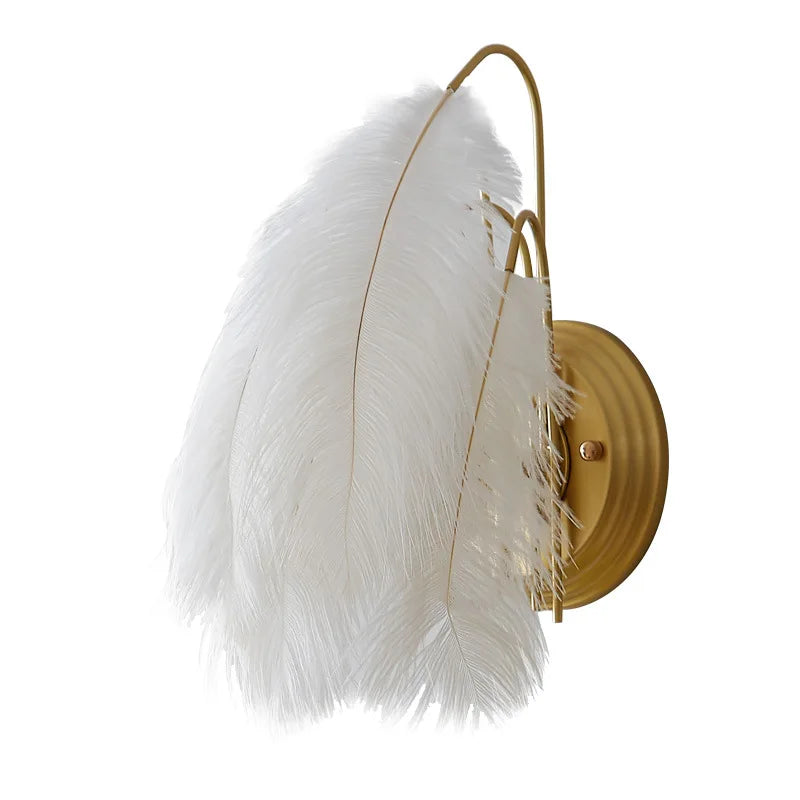 Wall sconce with white feathers and gold finish on a white background