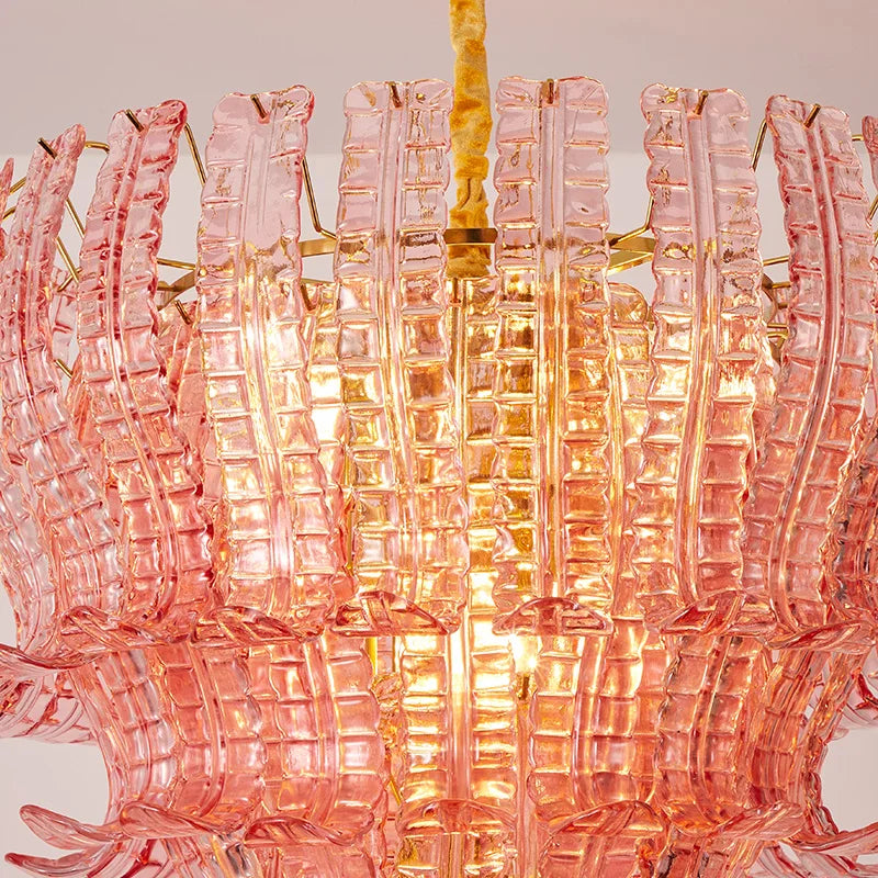 Pink glass chandelier with gold accents on a neutral background