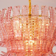 Pink glass chandelier with gold accents on a neutral background