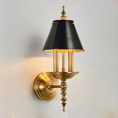Wall-mounted lamp with black shade and gold fixture on a light gray background