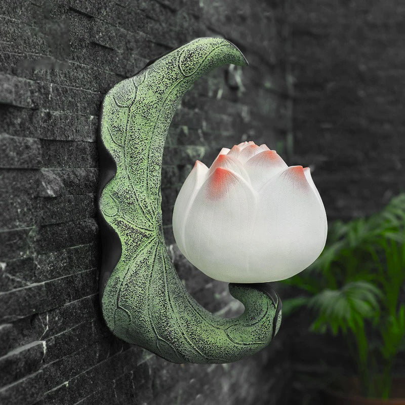 Decorative wall-mounted lotus light against a stone wall
