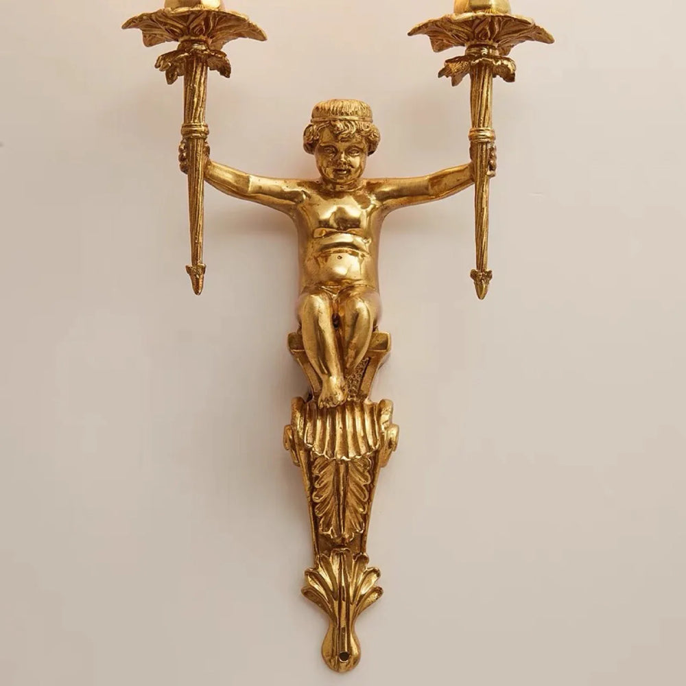 Gold wall sconce with cherub design on a beige background