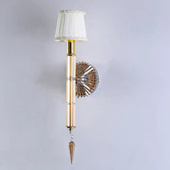 Decorative wall sconce with gold finish and white lampshade on a light gray background