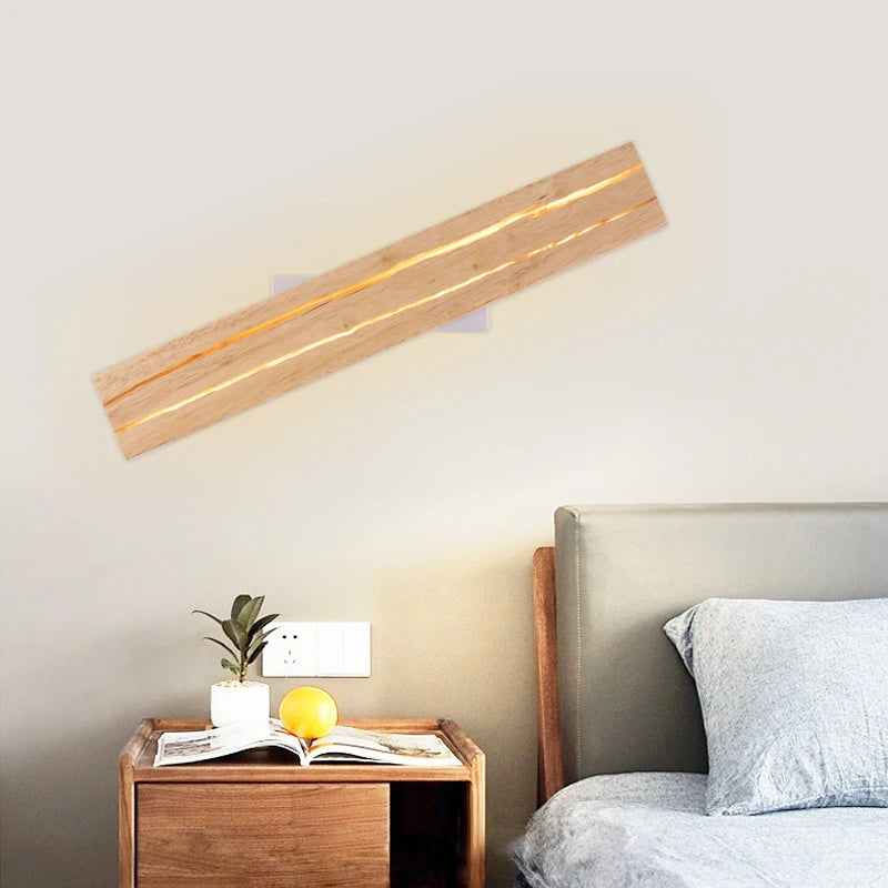 Wooden wall lamp on a wall above a bed with a nightstand.